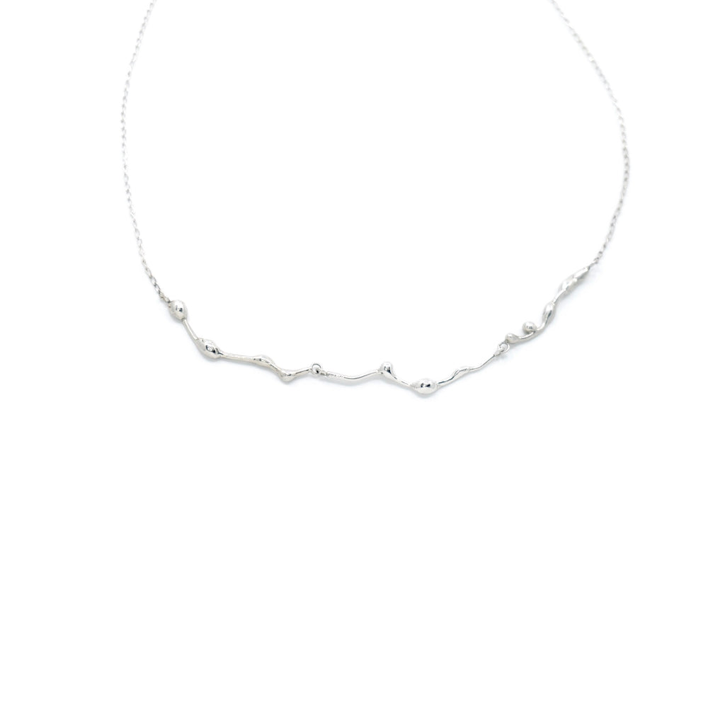 Handcrafted silver Naiad choker necklace by Atelier Objectora with an organic, water-inspired design, minimalist yet bold, perfect for layering or wearing alone. / Ručne vyrobený strieborný choker náhrdelník Naiad od Atelier Objectora s organickým dizajnom inšpirovaným vodou, minimalistický, no výrazný, ideálny na vrstvenie alebo nosenie samostatne.