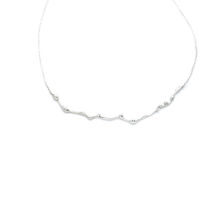 Handcrafted silver Naiad choker necklace by Atelier Objectora with an organic, water-inspired design, minimalist yet bold, perfect for layering or wearing alone. / Ručne vyrobený strieborný choker náhrdelník Naiad od Atelier Objectora s organickým dizajnom inšpirovaným vodou, minimalistický, no výrazný, ideálny na vrstvenie alebo nosenie samostatne.