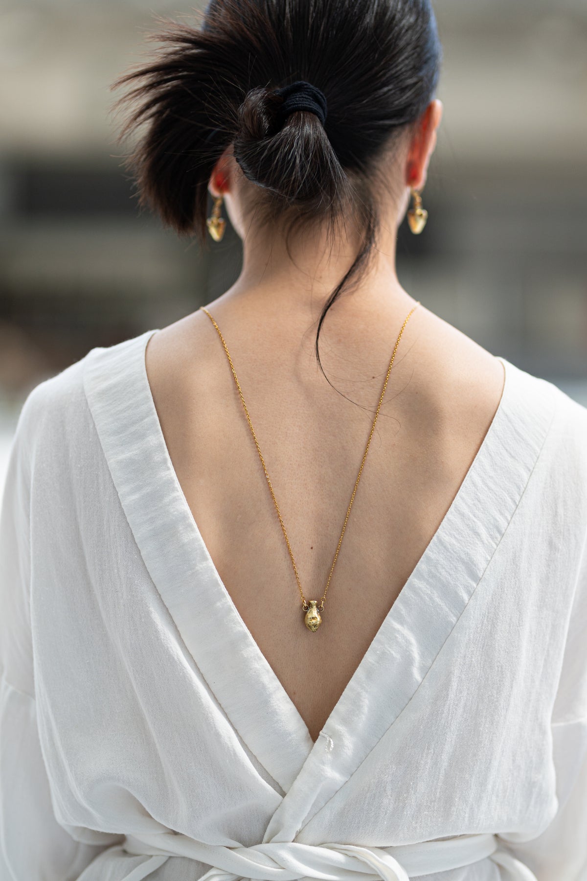 Handcrafted brass Vessel pendant necklace by Atelier Objectora, featuring a delicate amphora-shaped pendant on a gold-plated stainless steel chain. Inspired by ancient vase, sculptural piece 

Ručne vyrobený mosadzný príveskový náhrdelník Vessel od Atelier Objectora s jemným príveskom v tvare amfory na pozlátenej nehrdzavejúcej oceľovej retiazke. Inšpirovaný starovekou vázou, sochársky šperk 