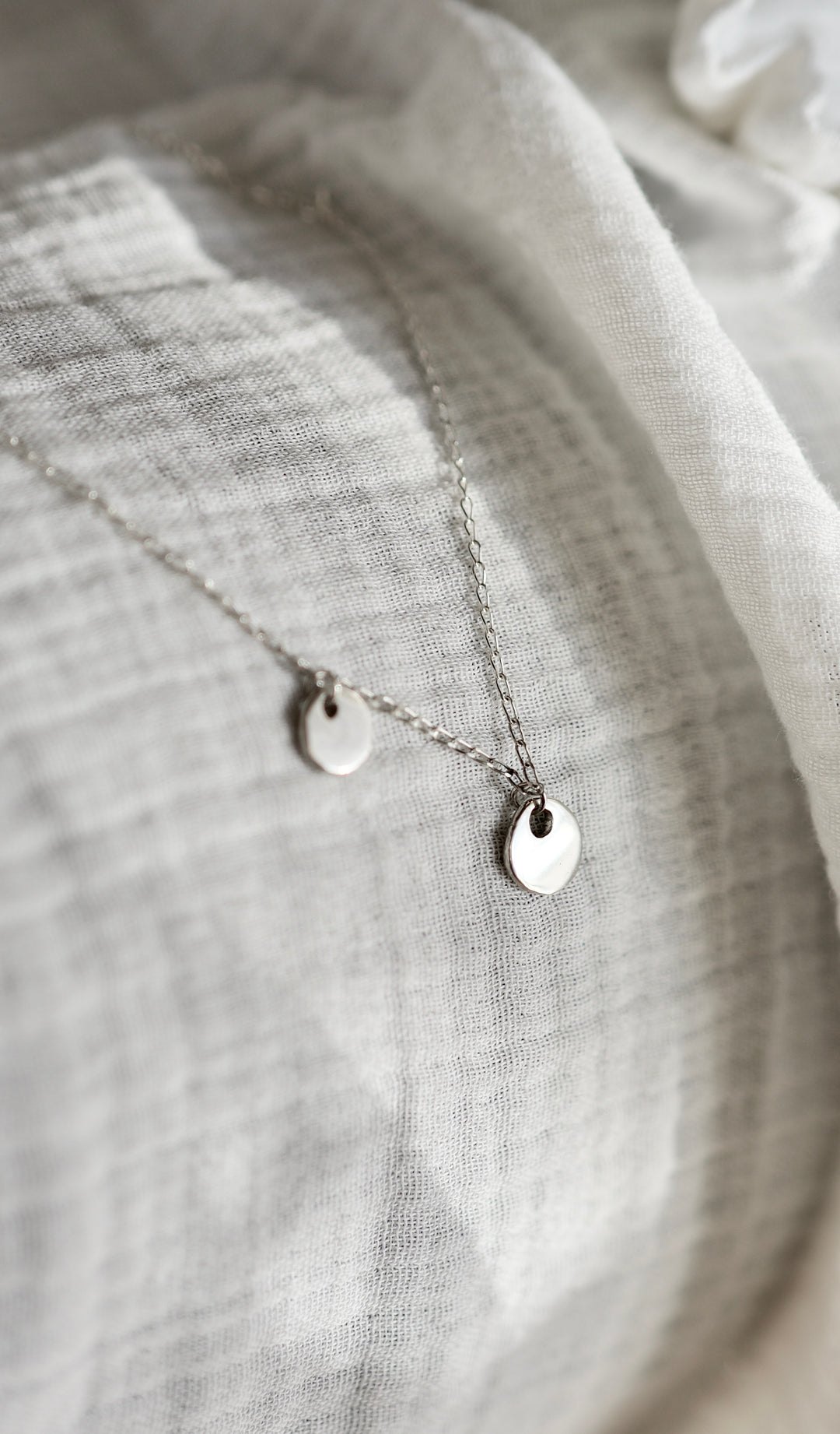 Handcrafted silver organic coin pendant necklace by Atelier Objectora, featuring a irregular medallion design, timeless and versatile

 Ručne vyrobený strieborný náhrdelník s organickým okrúhlym príveskom od Atelier Objectora, s nepravidelným medailónom, nadčasový a univerzálny